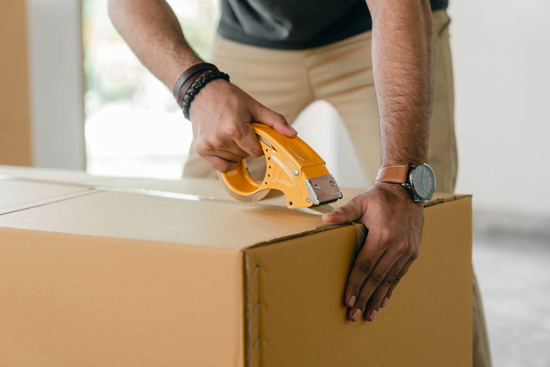 person taping a box shut